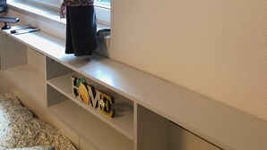 Ein Zimmer mit Fenster, ein Zitronenbild und ein Regal mit Buchstaben.