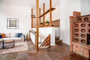 A living room with a sofa, coffee table, and a fireplace. - Holiday Home 'Zum Wohlfühlen In Xanten' with Private Garden, Balcony and Wi-Fi (Xanten)