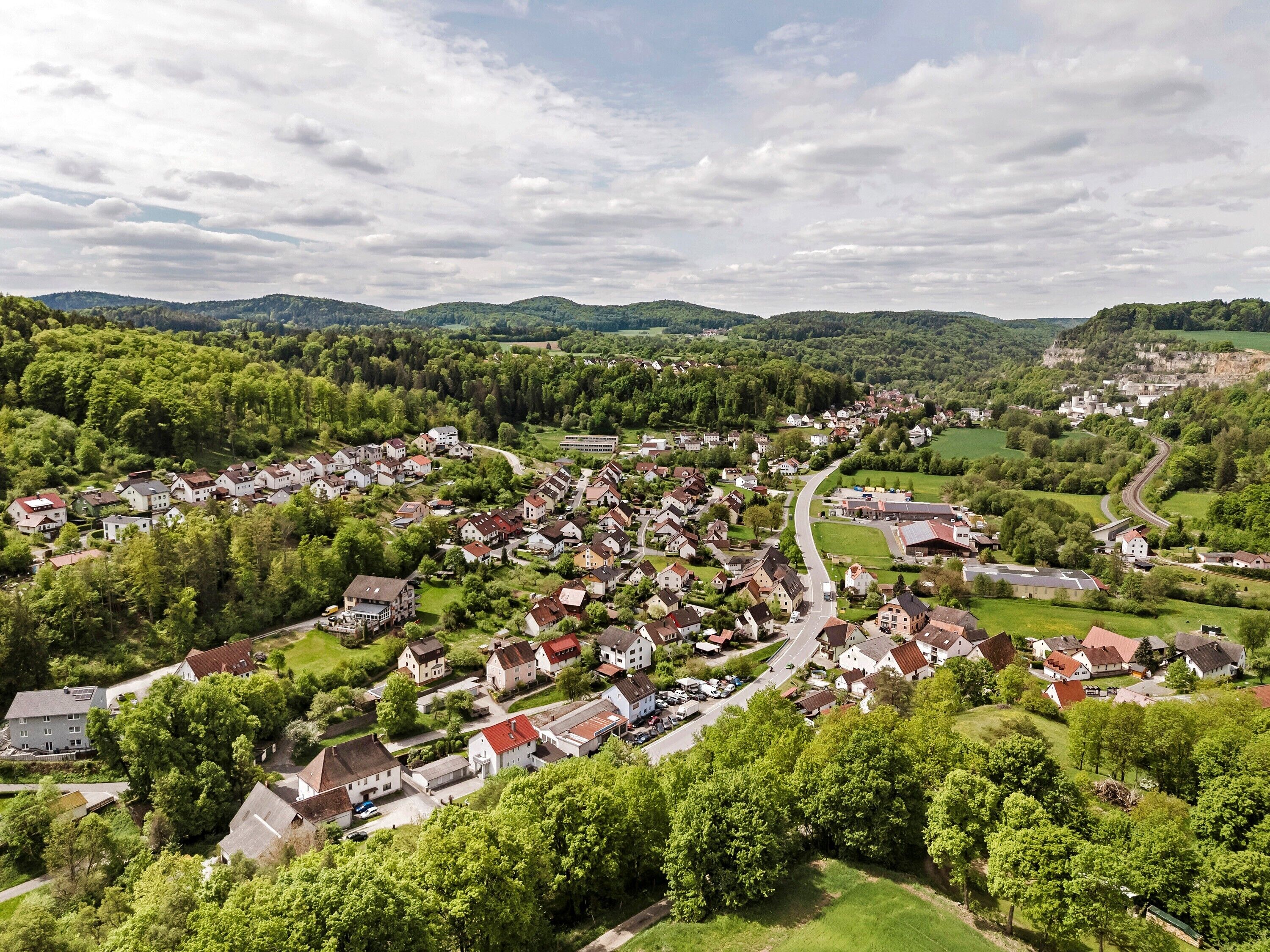 A residential area with houses, roads, and surrounding greenery.