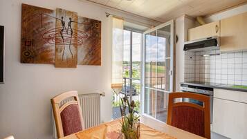 Una cocina con una mesa de comedor, sillas, un radiador y obras de arte en la pared.