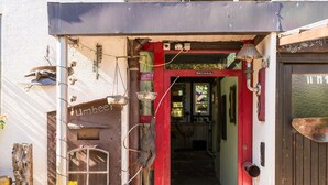 A rustic entrance with a wooden door, a metal scale, and a hanging flower basket. - Room 'Doppelzimmer Mit Balkon' with Balcony and Wi-Fi (Schömberg)