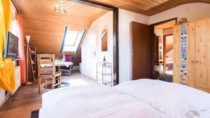 Une chambre comprenant un lit, un bureau, une chaise, une télévision et une armoire.