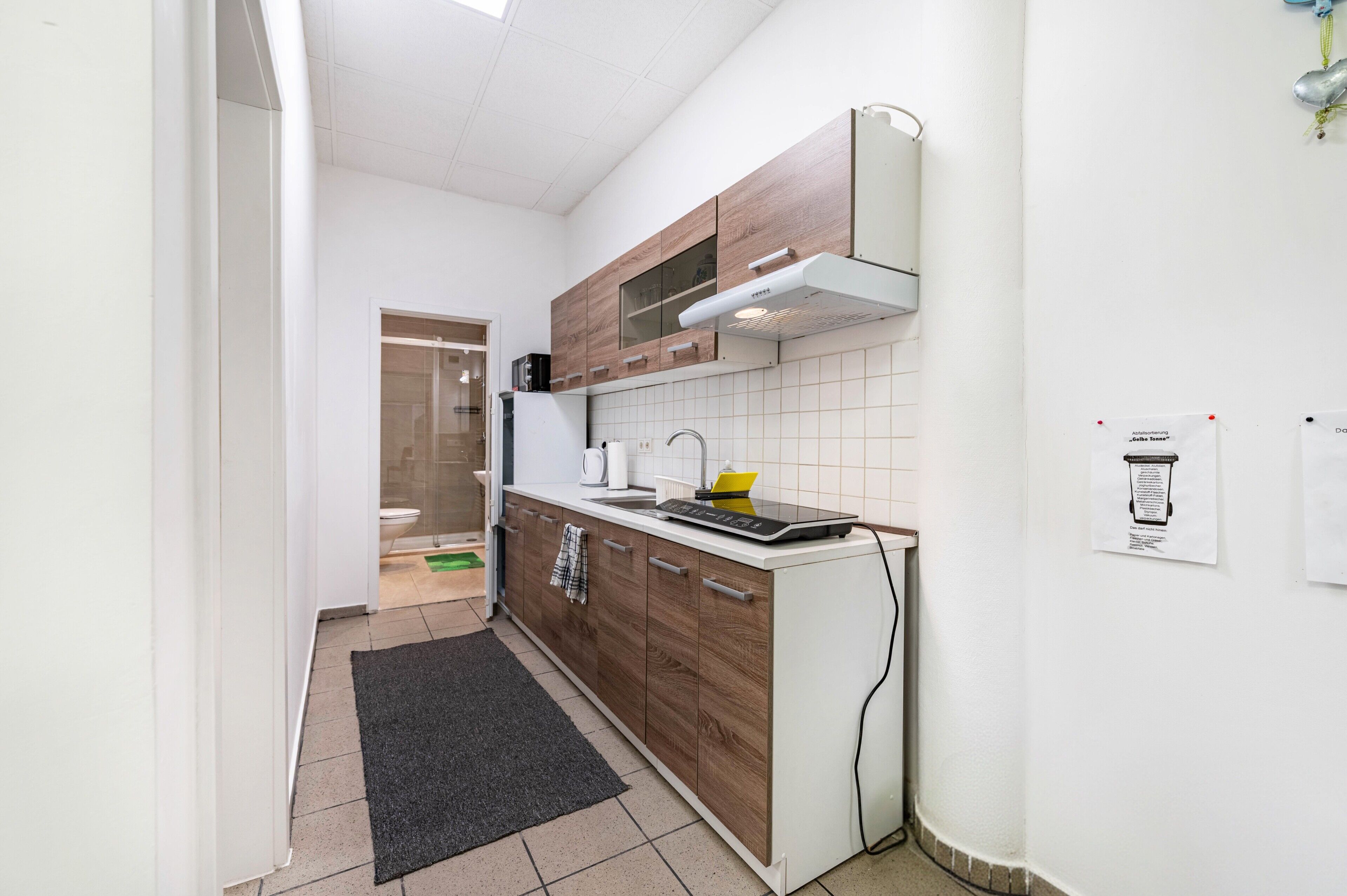 A compact kitchen with wooden cabinets, a built-in microwave, and a small countertop.
