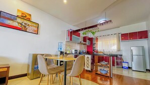 A modern kitchen with a dining area, featuring a refrigerator, microwave, and various kitchen appliances. - Salt & Sun Sanctuary (Mombasa)