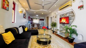 A modern living room with a black sofa, a glass coffee table, and a fireplace. - Salt & Sun Sanctuary (Mombasa)