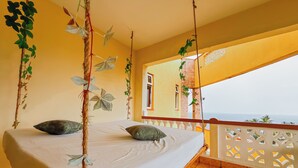 A room with a bed, a balcony with a view, and hanging plants. - Salt & Sun Sanctuary (Mombasa)
