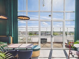 Un interior moderno con ventanas amplias, un comedor y vistas a la ciudad.