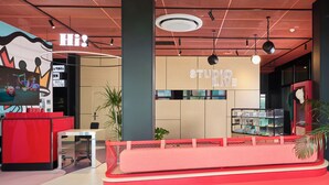 Un intérieur moderne comprenant un comptoir d’accueil, un espace détente et un mur sur lequel est inscrit le texte « STUDIO LOVE ».