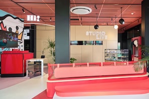 Een modern interieur met een receptiebalie, een zithoek en een muur met de tekst 'STUDIO LOVE'.