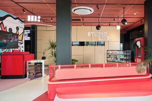 Un interior moderno con un mostrador de recepción, una zona de estar y una pared con el texto 'STUDIO LOVE'.