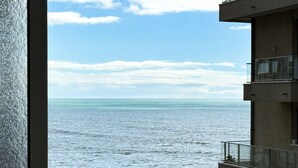 A view of the sea from a balcony overlooking a construction site with a white van and a yellow excavator. - La Rose Des Vents - Studio - Arago - Sea View (Les Sables-d´Olonne)