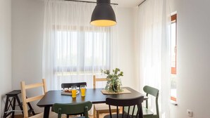 A dining area with a table, chairs, a potted plant, and a hanging light fixture. - 4 guests apartment in Medulin (Ližnjan)