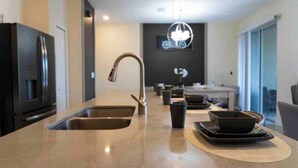 Una cocina moderna con una isla central, electrodomésticos de acero inoxidable y un diseño minimalista.