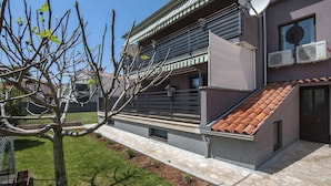 A modern building with a sloped roof, satellite dish, and air conditioning units.