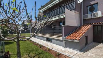 A modern building with a sloped roof, satellite dish, and air conditioning units.