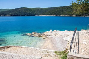A coastal view with clear blue waters, rocky shoreline, and a stone staircase leading down to the beach. - Sea View Apartment in Rabac (Rabac)