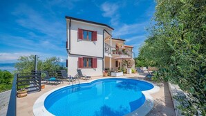 A two-story house with a swimming pool, outdoor furniture, and a view of the sea. - Apartment in Drenje with Stunning Sea View (Drenje)