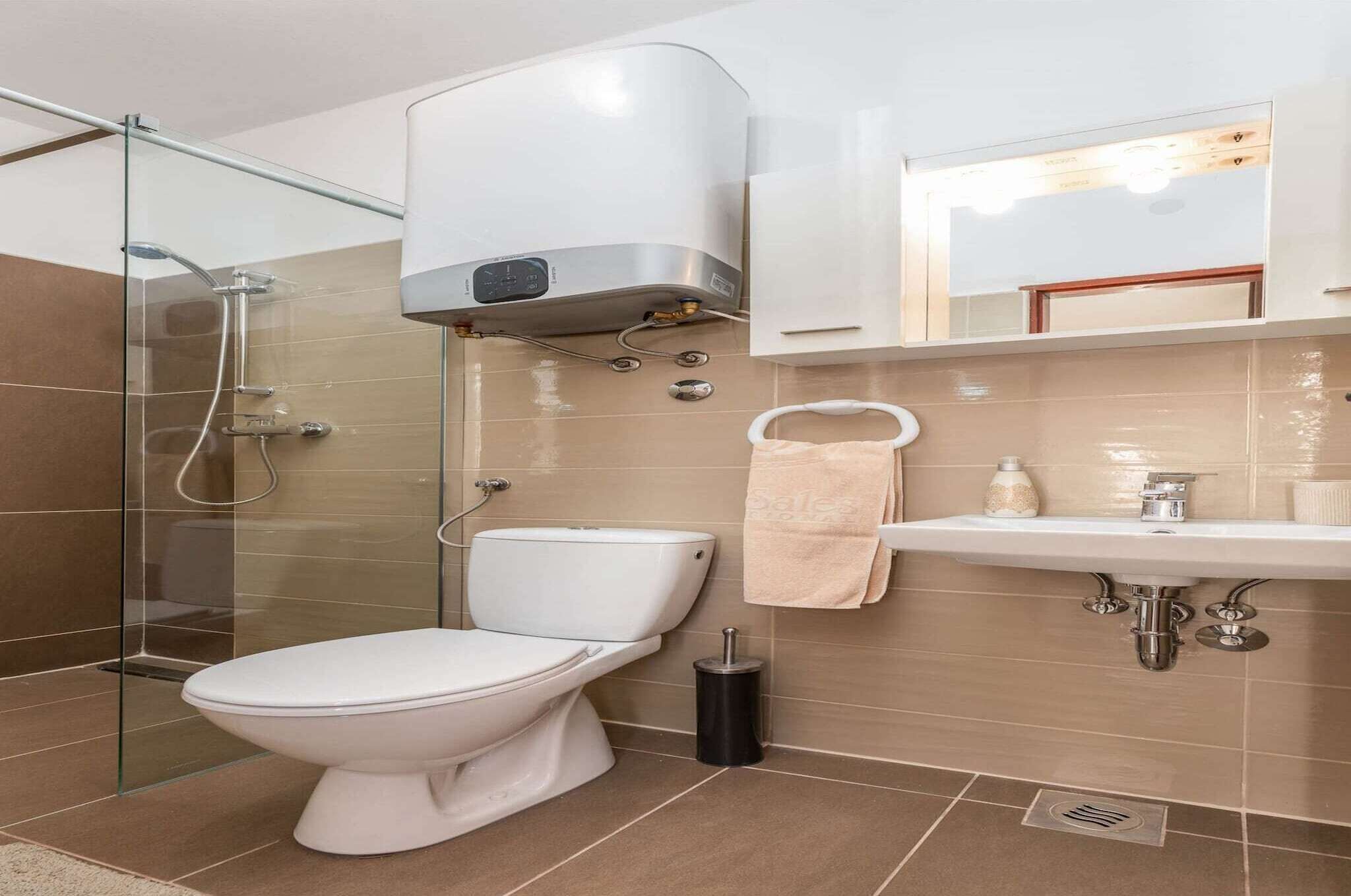 A modern bathroom with a toilet, shower, and sink.