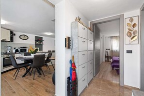 Een moderne keuken met een eethoek, een gang naar een slaapkamer en een decoratief wandobject.