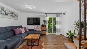Un salon moderne avec un canapé gris, une table basse en bois et un tapis en peau de vache.
