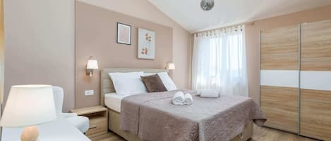 A neatly arranged bedroom with a bed, bedside lamps, a nightstand, and a wall-mounted shelf.