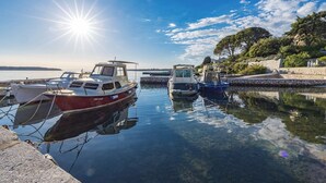 Un puerto deportivo con varias embarcaciones amarradas, agua tranquila y cielo despejado.