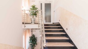Una escalera con barandas de metal y plantas en macetas.