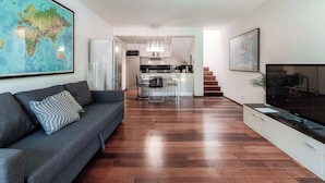 Appartamento Deluxe, patio, vista giardino | Area soggiorno | TV a schermo piatto 32 pollici con canali digitali