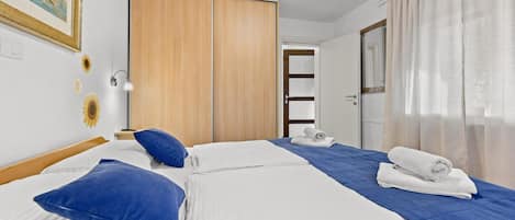 A hotel room with a bed, a wardrobe, a desk, and a bathroom door.