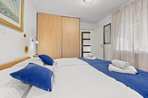 Une chambre d’hôtel avec un lit, une armoire, un bureau et une porte de salle de bain.