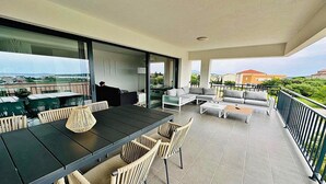 A spacious balcony with a dining area, seating, and a view of the sea. - Spacious apartment with wonderful sea view (Banjol)