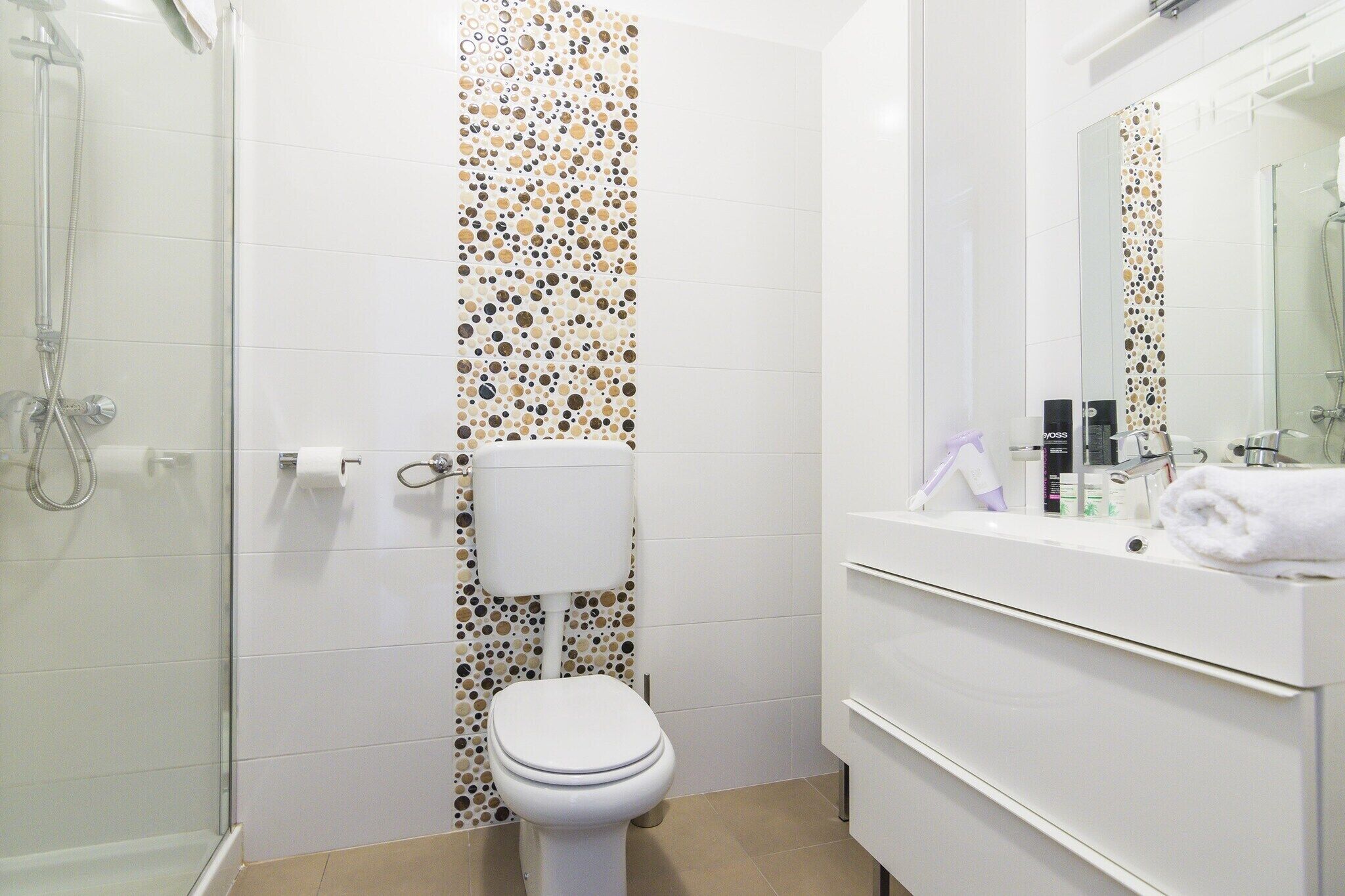 Un baño con inodoro, ducha y lavamanos.