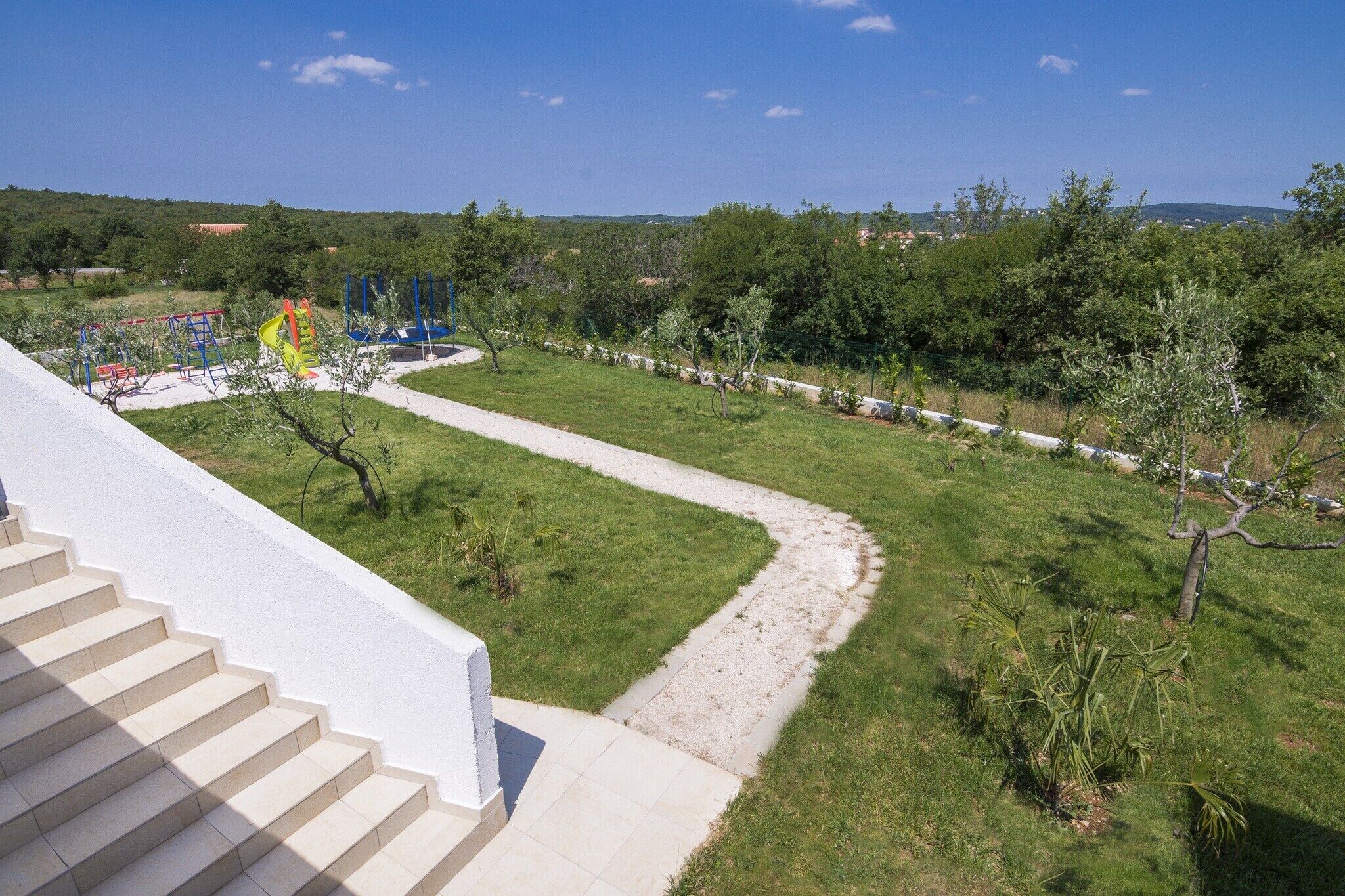 Un barrio residencial con un sendero que lleva a un parque infantil.