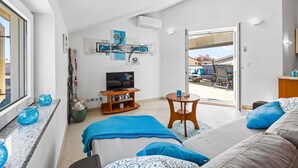 A modern bedroom with a TV, artwork, and a balcony view.