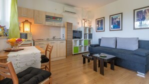 A compact living space with a kitchenette, a sofa, and a dining area. - Apartment in Labin near Rabac Beaches (Labin)