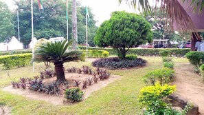 A landscaped garden with various plants and a palm tree. - U.I HOTEL (Ibadan)