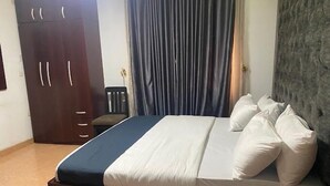 Ein Schlafzimmer mit einem Bett, einem Kleiderschrank und einem Sessel.