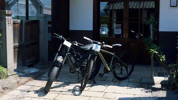 Deux vélos sont garés devant un bâtiment dont la porte et les fenêtres sont en bois.