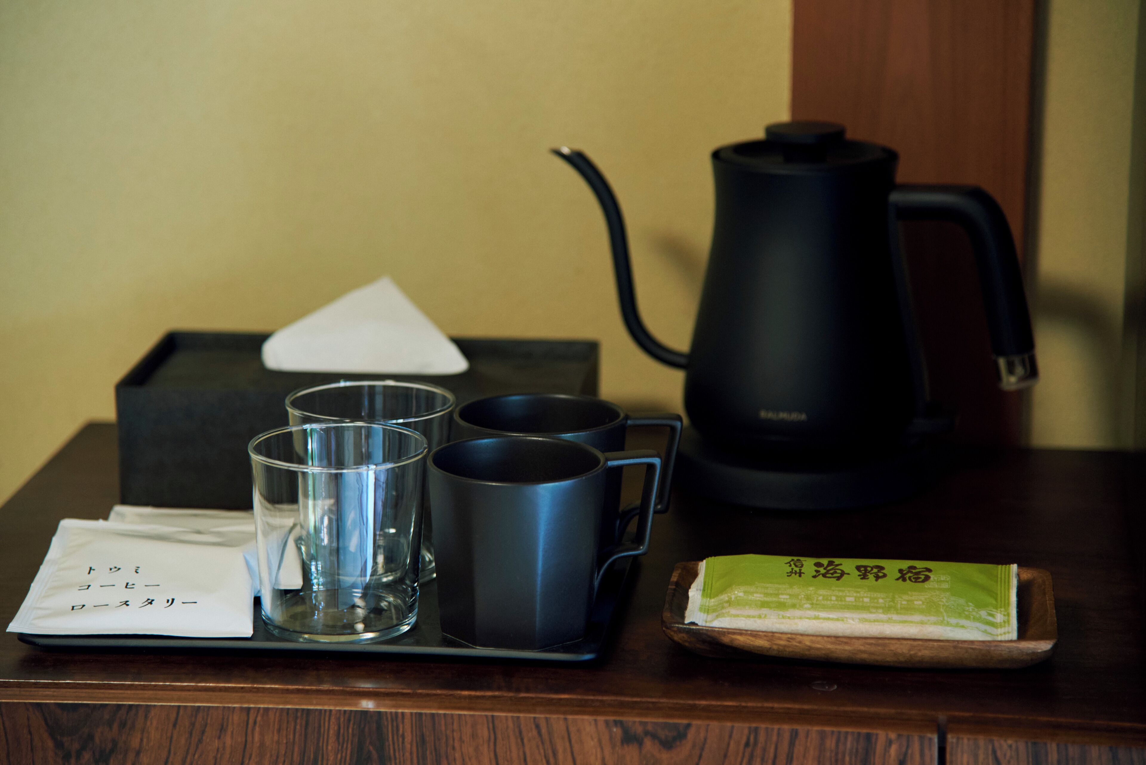A tray with a tea set, including a teapot, cups, and a tray of green tea.