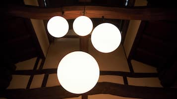 A ceiling with three spherical light fixtures and exposed wooden beams.