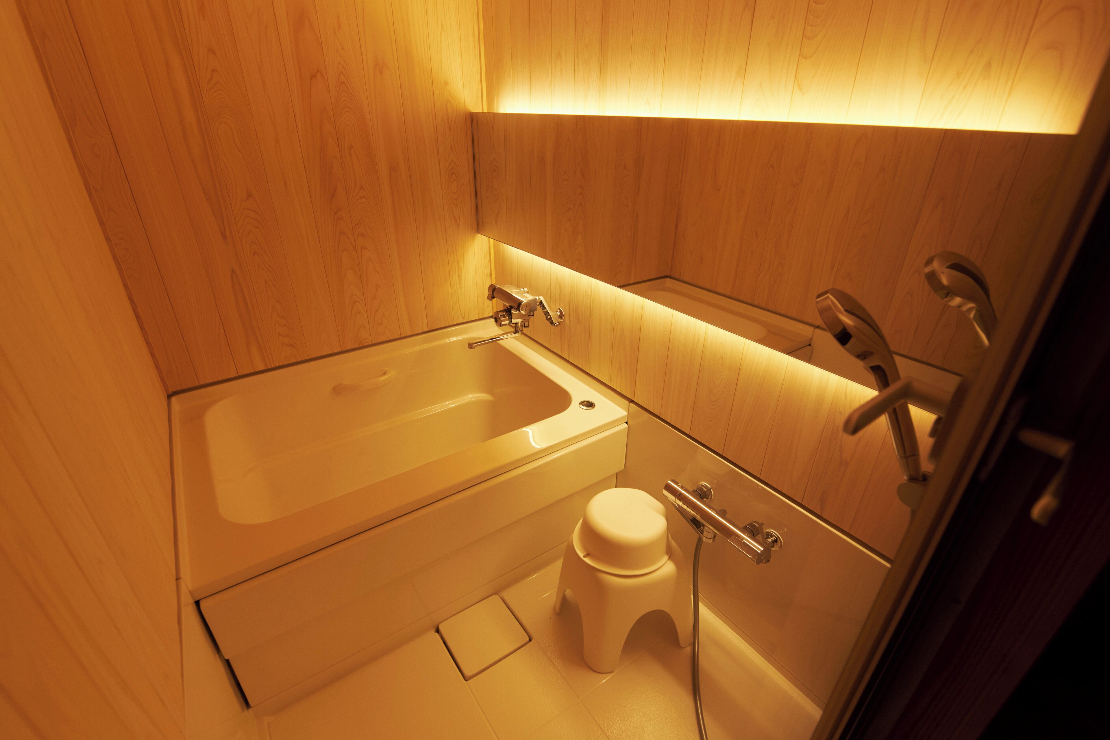 A small bathroom with a bathtub, toilet, and shower.
