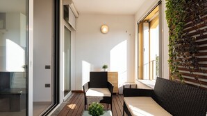 A modern interior with a sofa, a small table, and a chair. There is a potted plant on the table.