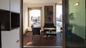 A balcony with a sofa, two chairs, and a small table.