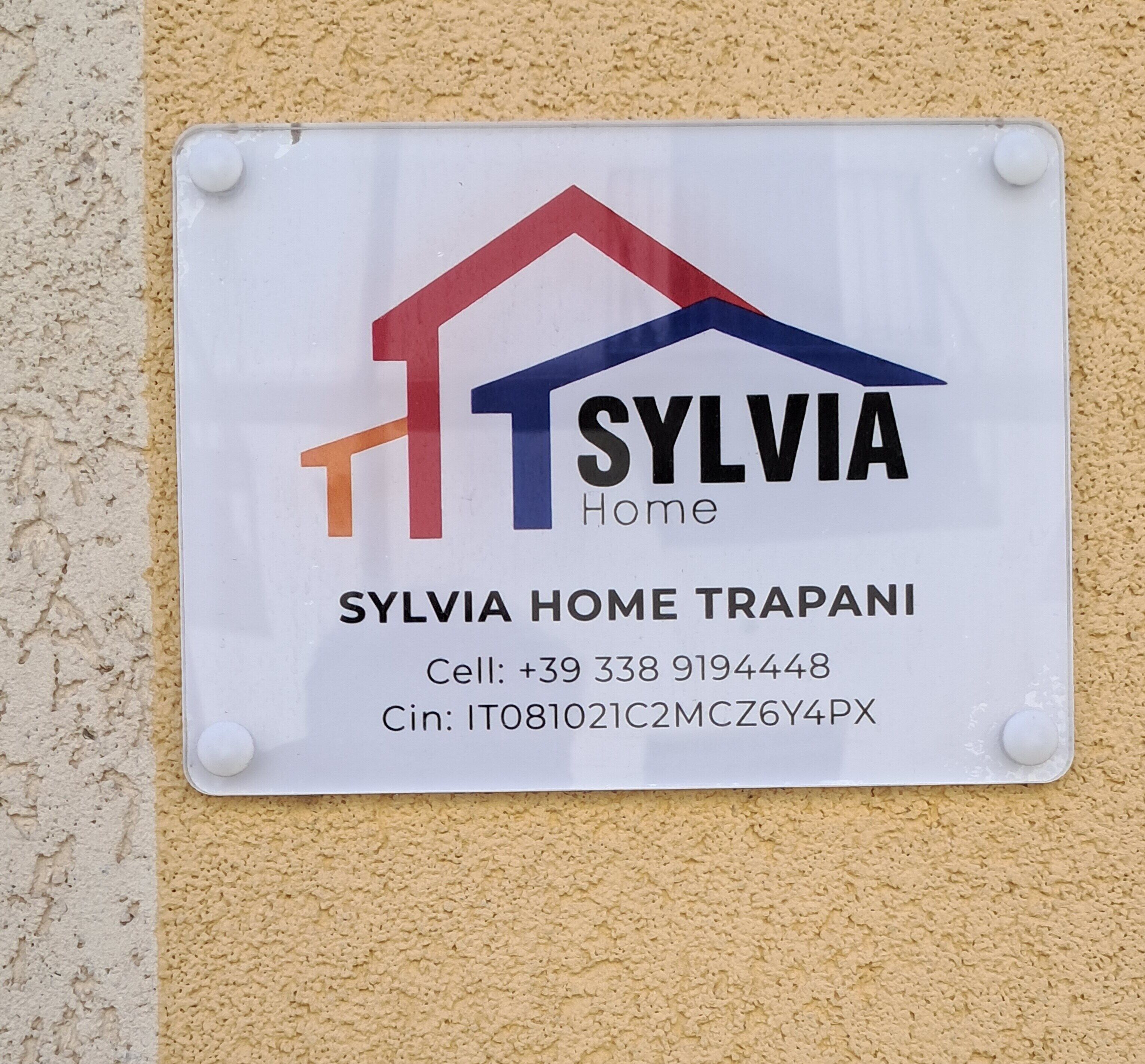 Ein Schild mit dem Namen 'SYLVIA Home' und Kontaktinformationen.