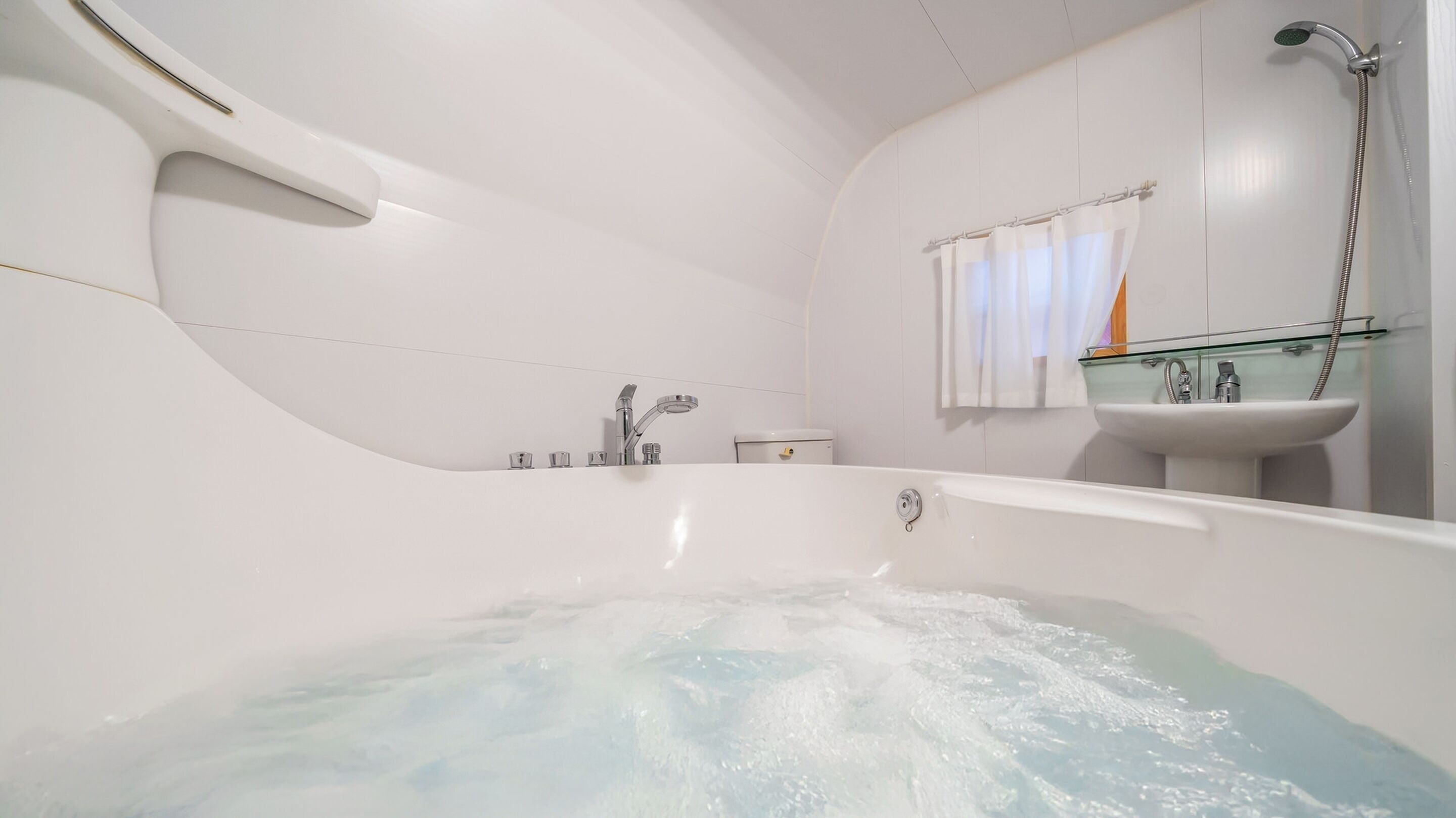 Ein modernes Badezimmer mit einer großzügigen Badewanne, einem in Glas eingefassten Waschbecken und einer Dusche.