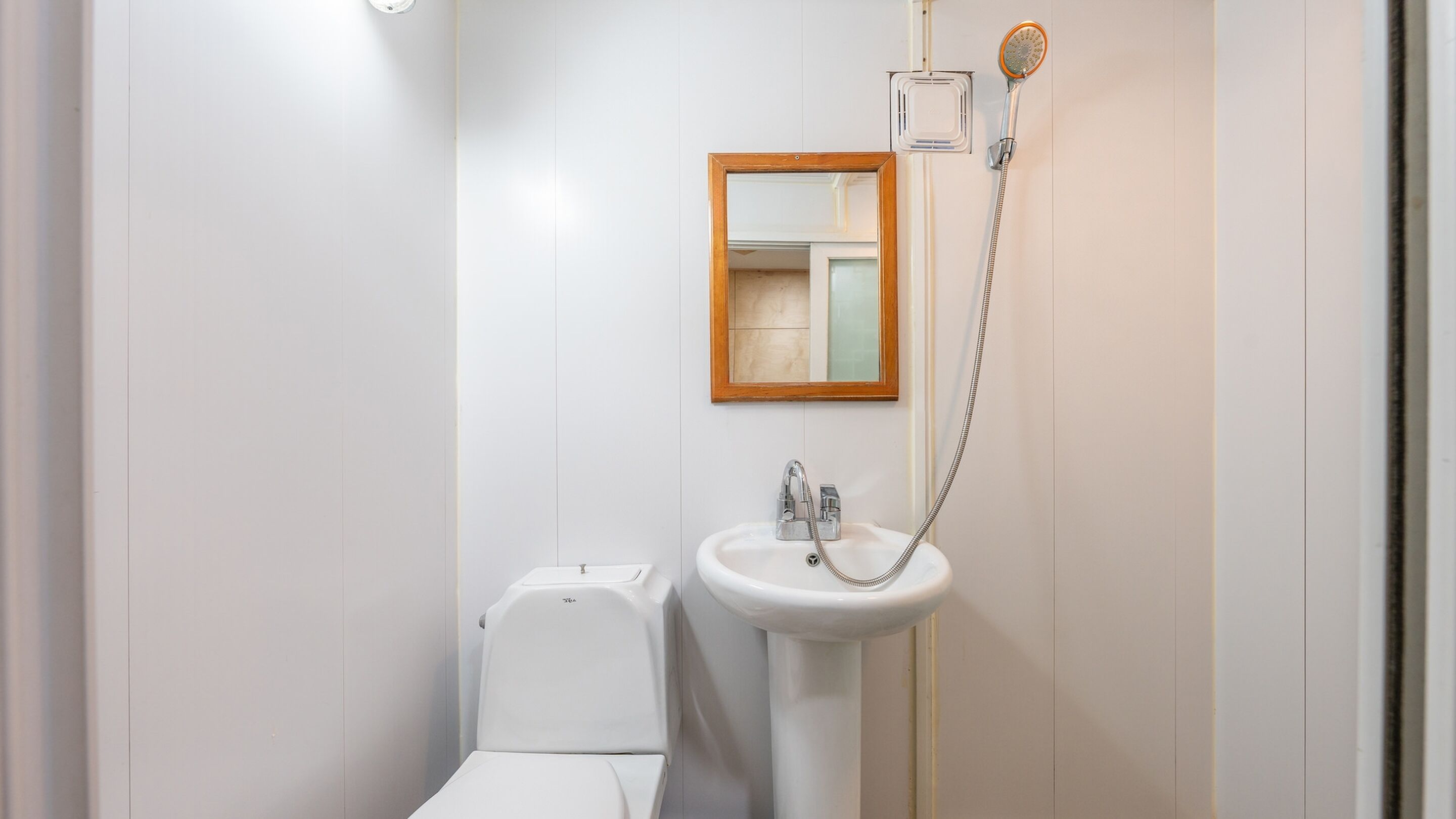 Un baño moderno con inodoro, lavamanos y ducha.