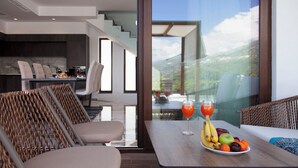 Zona de menjador moderna amb una taula preparada per a dues persones, amb un plat de fruita i dues flautes d'aigua de taronja.