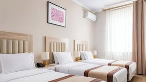 A hotel room with two beds, a framed picture on the wall, an air conditioning unit, and a window with curtains. - Sato Tashkent (Tashkent)