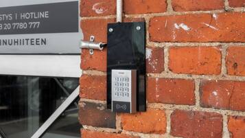 A keypad mounted on a brick wall, likely for a hotel or office building.