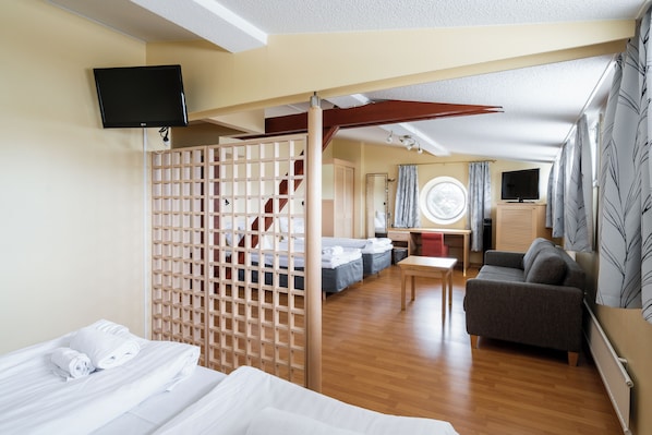 A hotel room with a bed, a sofa, a desk, and a TV. - Hiisi Hotel Turku Seaport (Turku)